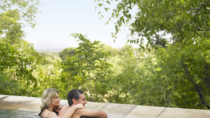 Rear view of an adult couple in pool looking at view