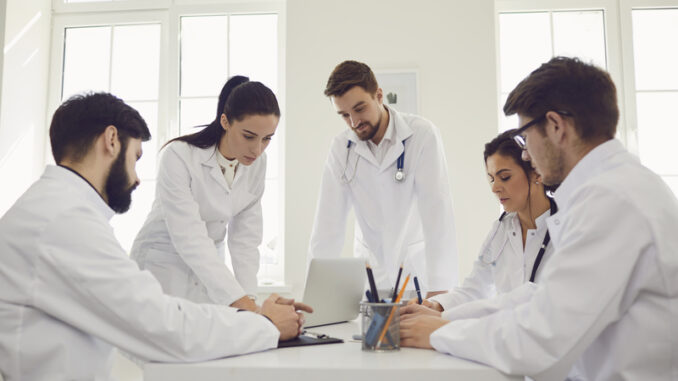 Group of doctors talking sitting at a table in the office of the hospital.