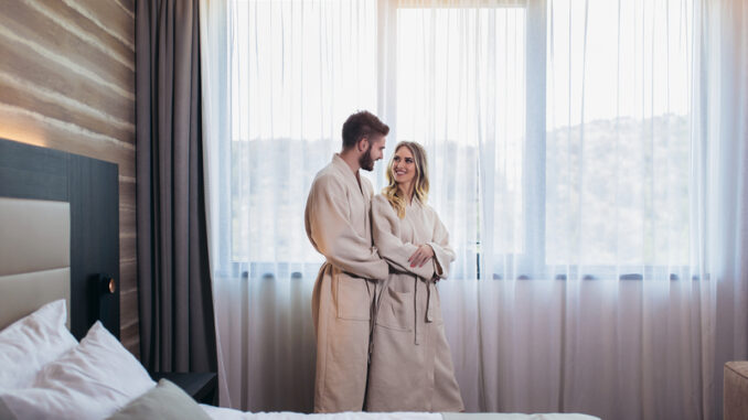 Young happy couple in hotel room in the morning.