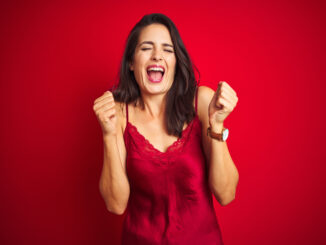 Young beautiful woman wearing lingerie over red isolated background excited