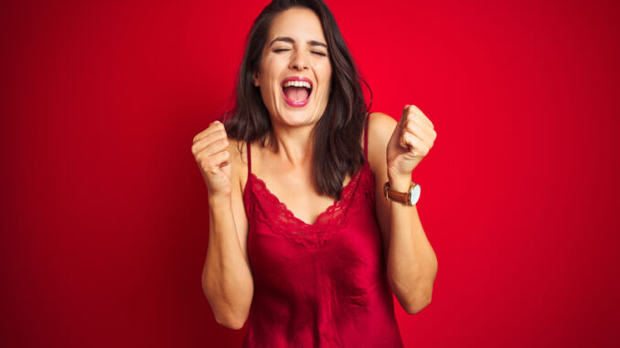 Young beautiful woman wearing lingerie over red isolated background excited