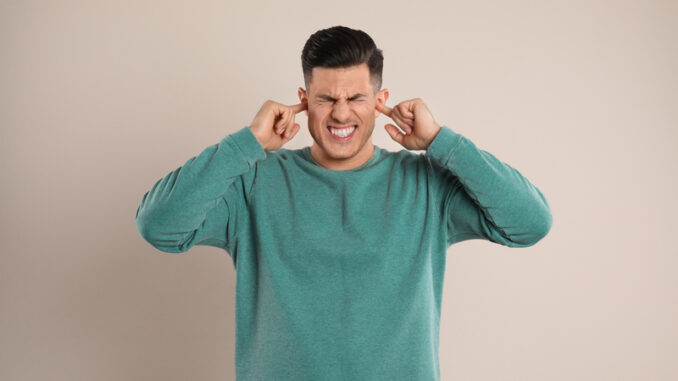 man covering ears with fingers