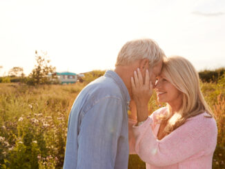 Loving Mature Couple In Countryside Head To Head Against Flaring Sun