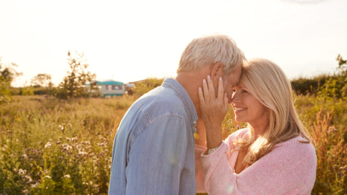 Loving Mature Couple In Countryside Head To Head Against Flaring Sun