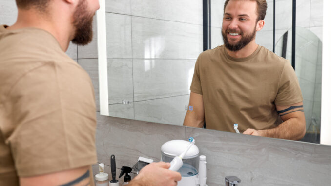 Bearded Male Person Brushing Teeth Using Electric Toothbrush