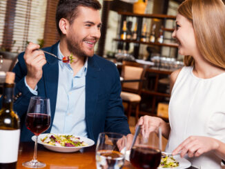 Beautiful young loving couple enjoying dinner at the restaurant