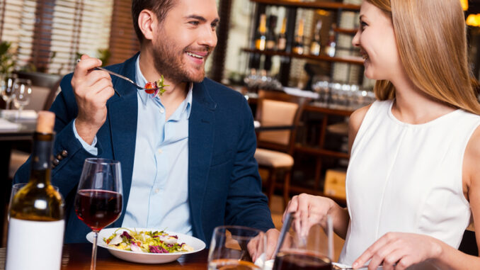 Beautiful young loving couple enjoying dinner at the restaurant