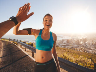 Fit young women high fiving her boyfriend after a run.