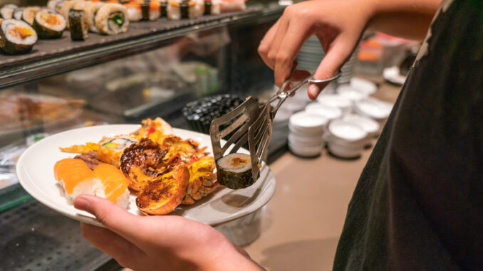 Man hand choosing sushi, lobster in the luxury buffet