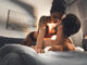 Selective focus of young couple lying in bed during foreplay