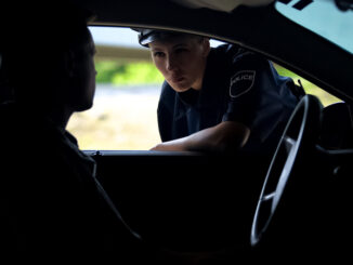 Police women talking with driver in car, inspection on road, traffic offence, stock photo