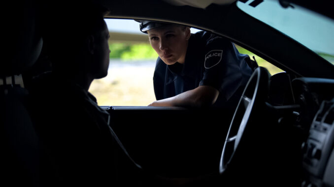 Police women talking with driver in car, inspection on road, traffic offence, stock photo