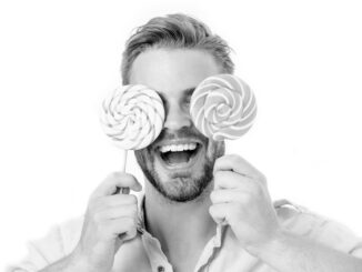 Happy guy with candy glasses isolated on white background