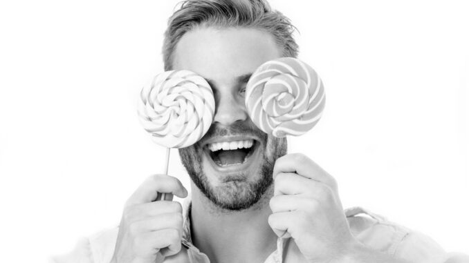 Happy guy with candy glasses isolated on white background