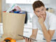 Man after grocery shopping using a digital touch screen tablet