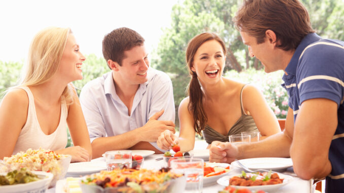 Two young couples eating outdoors Smiling