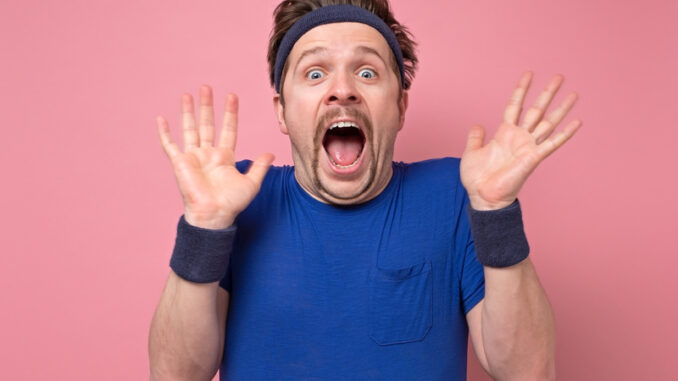dreamstime_s_174473968 Young man wearing sport clothes shocked with his results