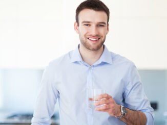 Man in kitchen with glass of water