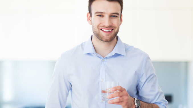 Man in kitchen with glass of water