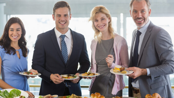 business colleagues serving themselves at buffet lunch in a restaurant