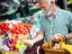 Handsome senior man shopping for fresh vegetable and fruit in a market