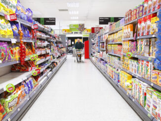 Elderly man grocery shopping in aisle.