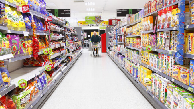 Elderly man grocery shopping in aisle.