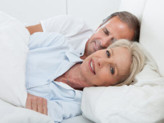 Portrait Of Happy Senior Couple Together In Bed