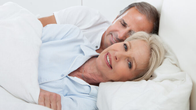 Portrait Of Happy Senior Couple Together In Bed