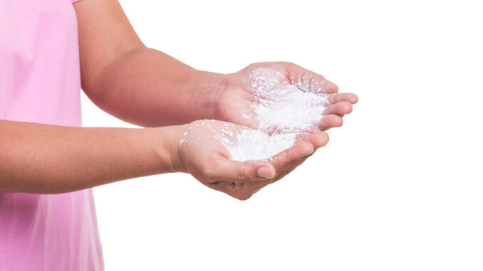 Woman holding white powder isolated on white background