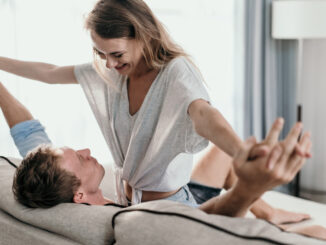 Affectionate couple lying on a couch looking at each other.