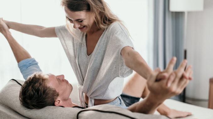 Affectionate couple lying on a couch looking at each other.