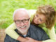 a happy older men with beautiful women smiling outdoors