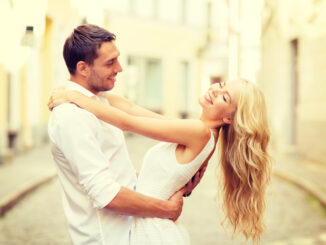 smiling couple dancing in the city