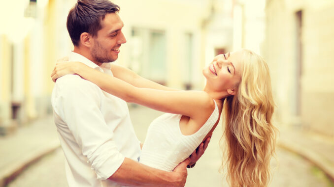 smiling couple dancing in the city