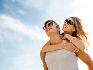 smiling couple having fun over sky background.