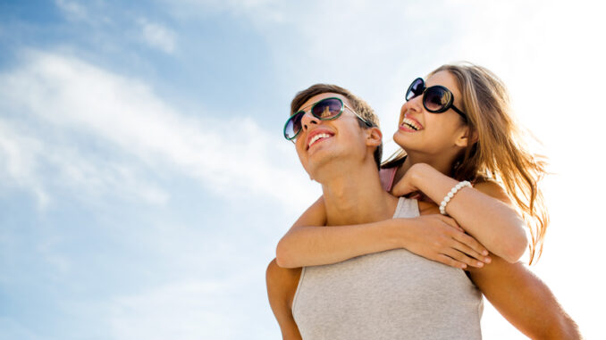 smiling couple having fun over sky background.